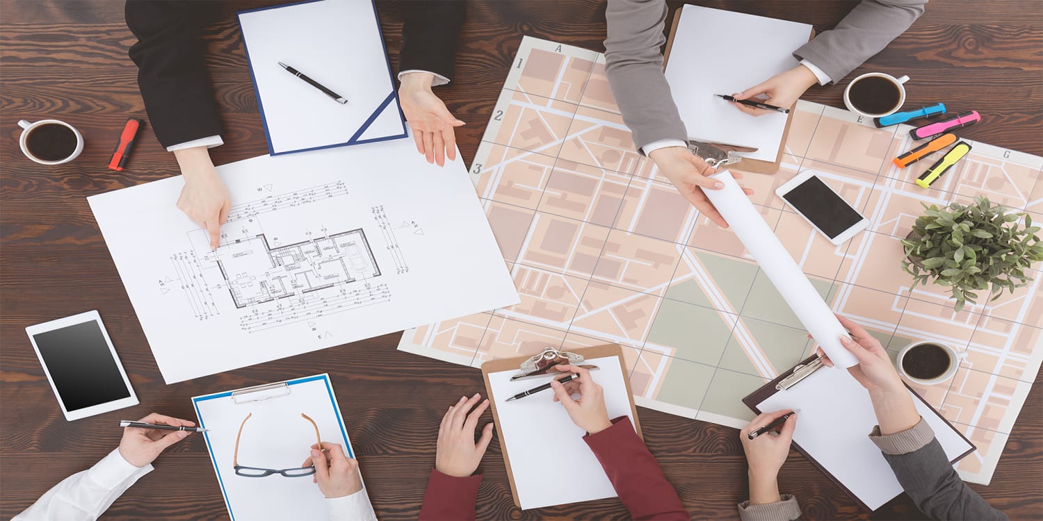 Real estate investors collaborating with plans